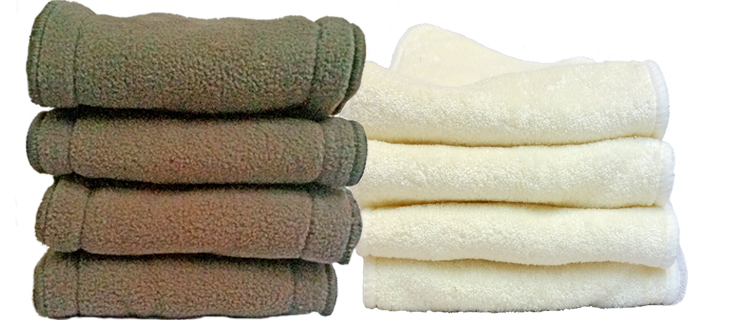 two folded piles of diaper inserts placed next to each other. The one on the left is charcoal bamboo inserts and the other pile iis cream colored diaper inserts